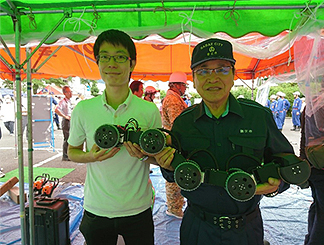 ヘビ型ロボットを抱える牧野百男 鯖江市長（右）と田中基康准教授（左）
