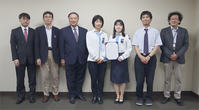 出席者による集合写真(中央は覚書を手にするガールスカウト東京都第178団の横式団委員長、小田リーダー)
